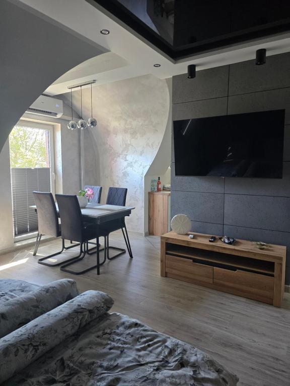 a living room with a dining table and a tv at Eleganckie Lokum in Malbork