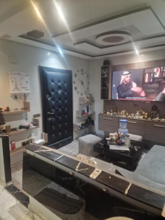 a living room with a table and a tv at apparemment wifaq in Temara