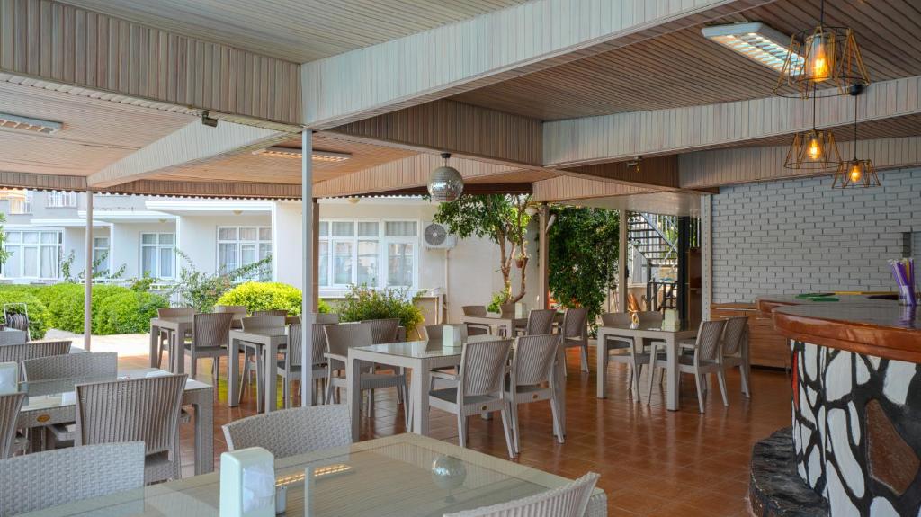 a restaurant with tables and chairs in a room at Side Özgürhan Hotel in Side