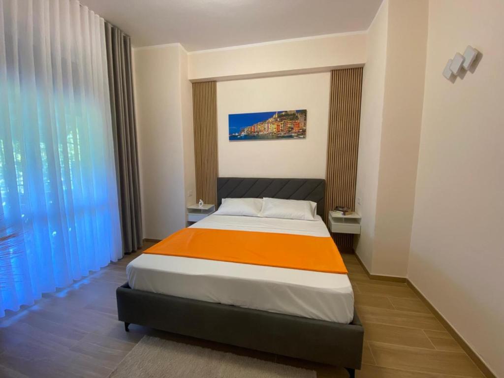 a bedroom with a bed with an orange blanket at Perla Blu House in La Spezia