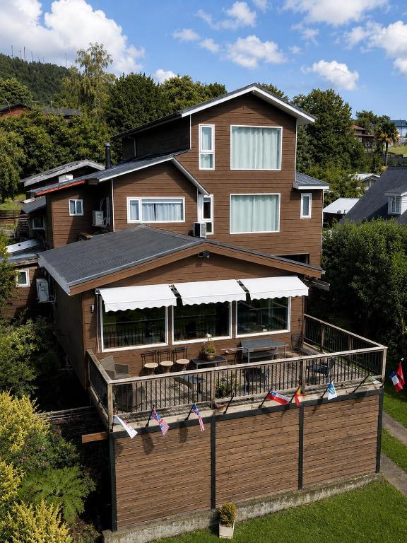 a house with a deck with flags on it at Hostal Lago Ranco Boutique in Lago Ranco
