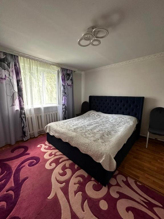 a bedroom with a bed and a red carpet at Guest House Sveta in Saty