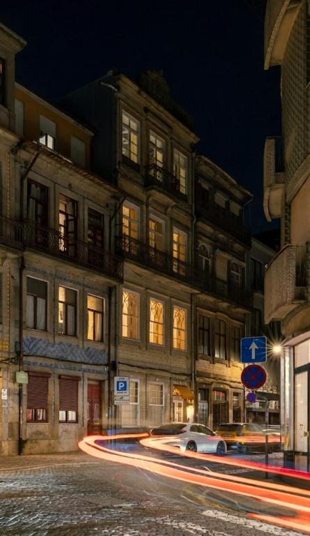 a car driving down a street in front of a building at Palace Museum & National Monument - Espaço Palmeiras in Porto