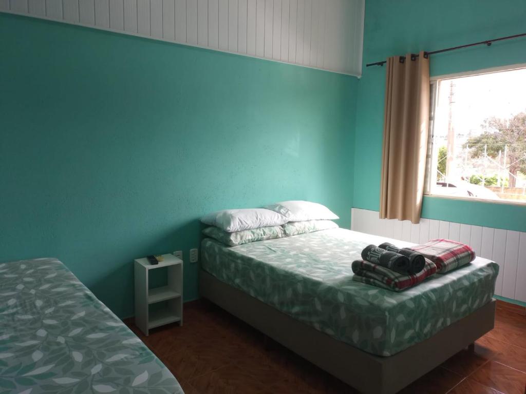 a bedroom with two beds and a window at Suíte Gigá 1 in Brotas