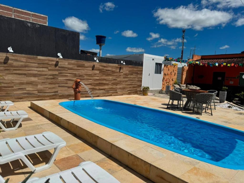 a swimming pool with a fountain on a patio at Pousada Villa Sítio in Campina Grande