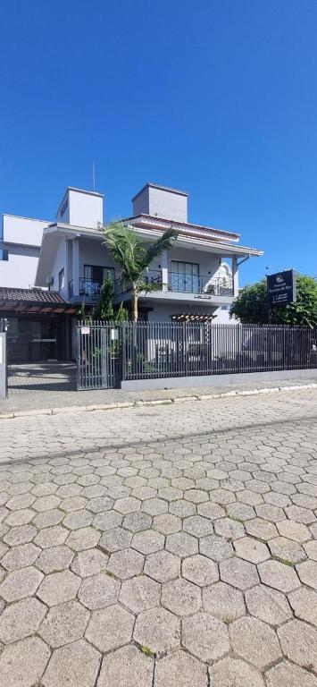 a building with a fence in front of a house at Pousada Recanto do Mar in Navegantes