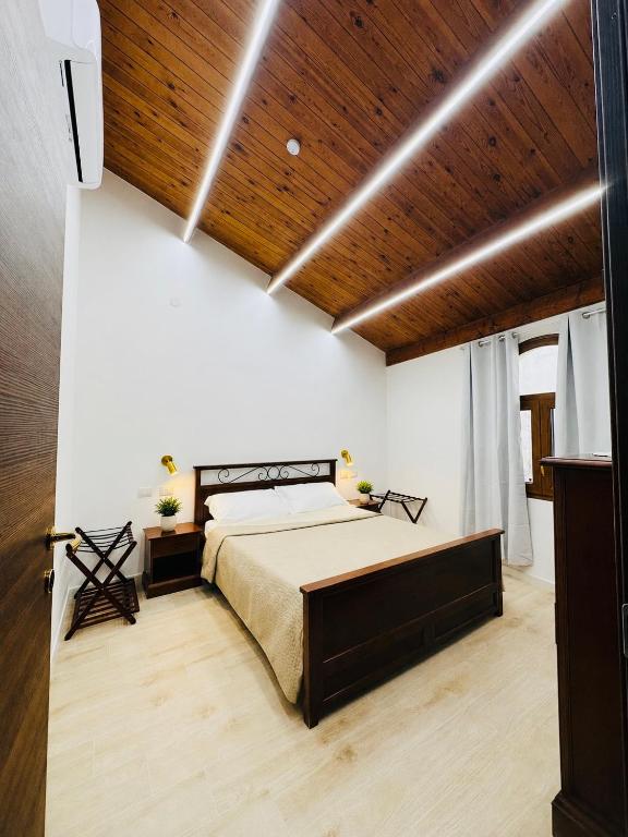a bedroom with a bed and a wooden ceiling at TBS House in Alghero