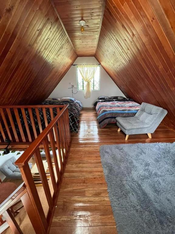 a attic room with a couch and a bed at La cabaña in Sotaquirá