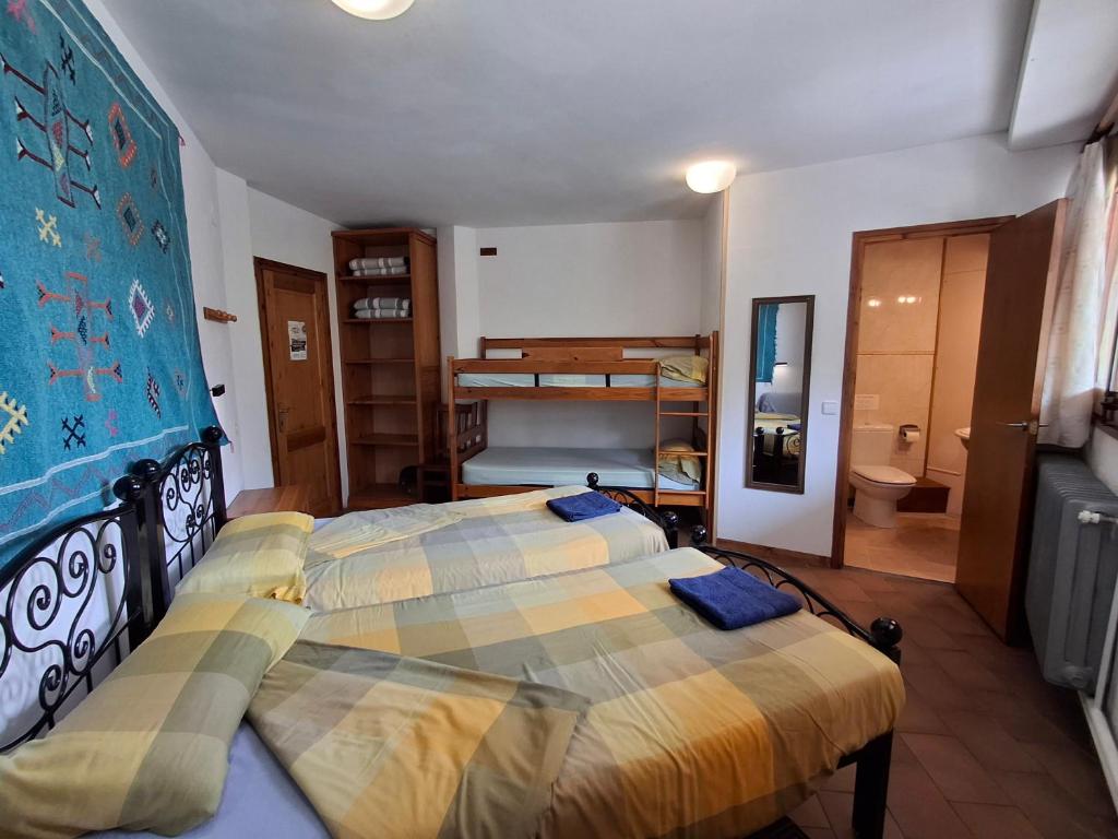 a bedroom with two beds and a bunk bed at Setcases-Vallter hostal Mitja Pensió 2 in Setcases