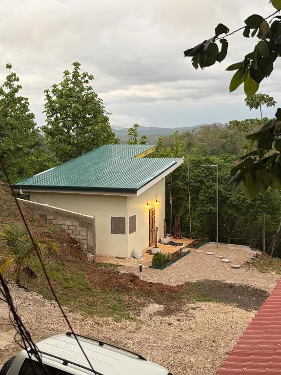 a small white house with a green roof at The Jungle Chalet in Cebadilla