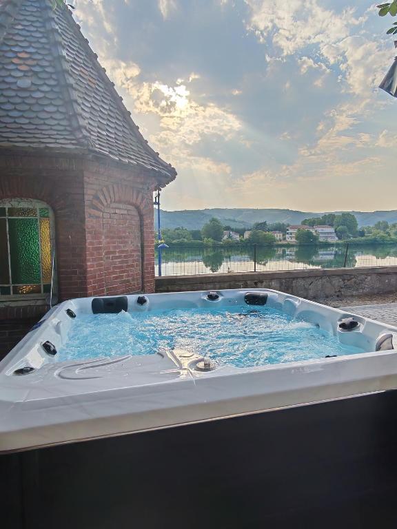 a jacuzzi tub with a view of the water at L'Escale du Rhône de 1 à 8 personnes in Saint-Vallier
