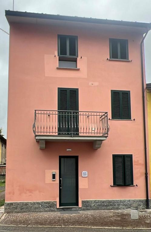 a pink building with a balcony and a door at Da Paola 