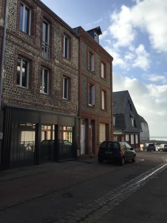 um carro estacionado em frente a um edifício de tijolos em Les Roches Yportaises em Yport