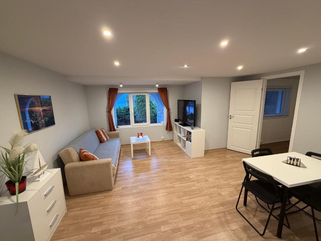a living room with a couch and a table at Sukkertoppen Apartment in Ålesund