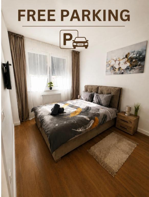 a bed in a bedroom with a poster for free parking at Apartment VIP in Subotica