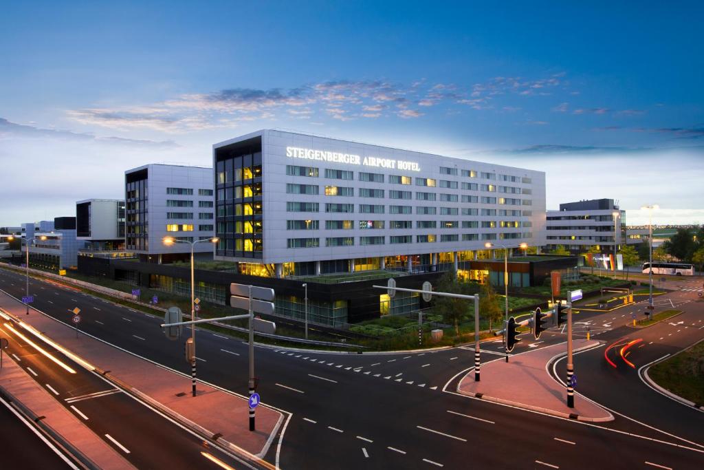 un grand bâtiment dans une rue de la ville avec une autoroute dans l'établissement Steigenberger Airport Hotel Amsterdam, à Schiphol