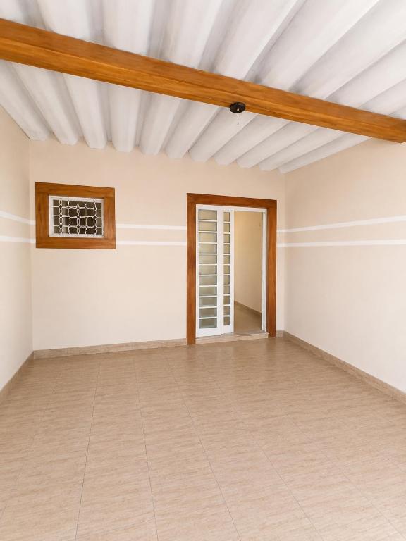an empty room with white walls and a wooden ceiling at Pousada CTI in Taubaté
