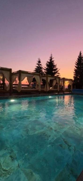 a large swimming pool with blue water at dusk at Hill residence A 119 Boby in Cajetina