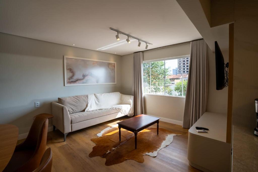 a living room with a couch and a window at Ap de novela no centro da cidade com garagem in Toledo