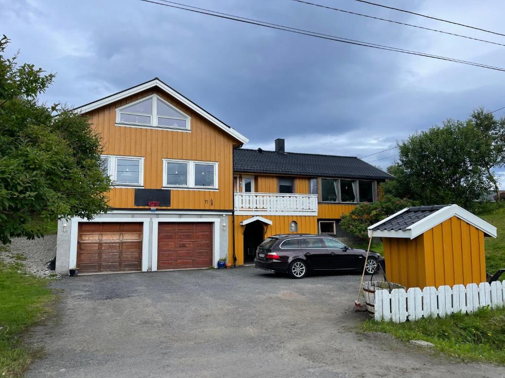 a house with a car parked in a driveway at House under the Aurora Cozy Private Home with Fireplace in Laukvik