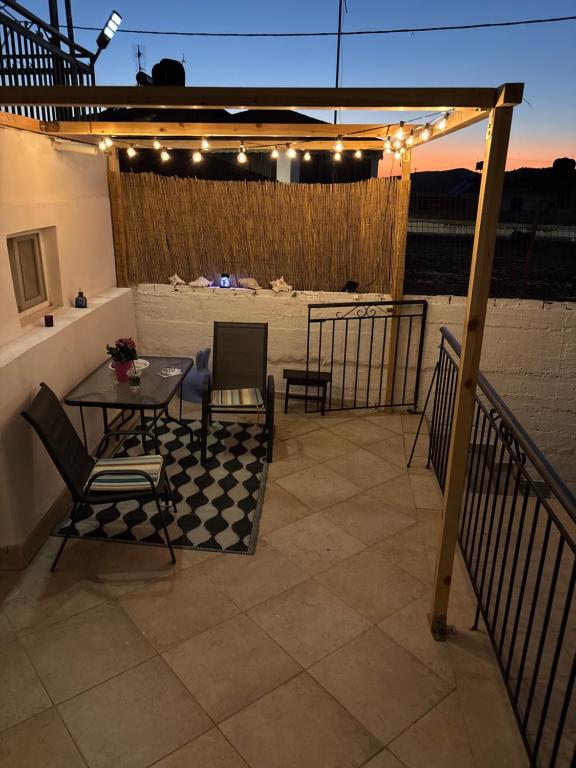 a patio with a table and chairs and lights at Alfeios cozy stays - Rustic 
