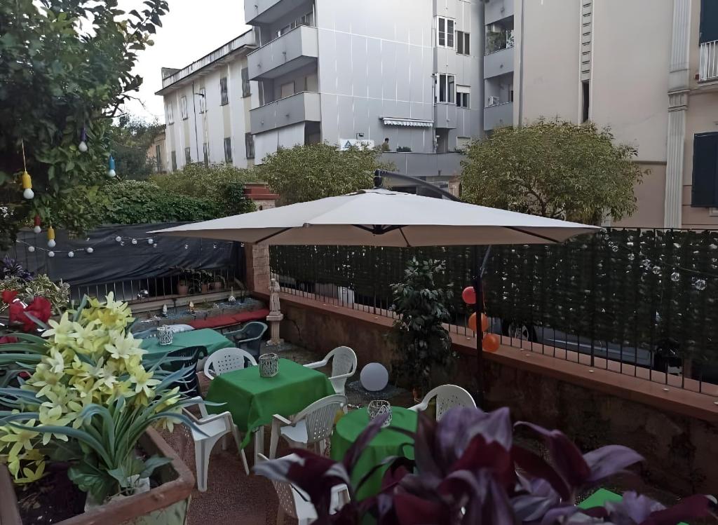 a patio with tables and chairs and an umbrella at Home Joséphine - Caserta in Caserta