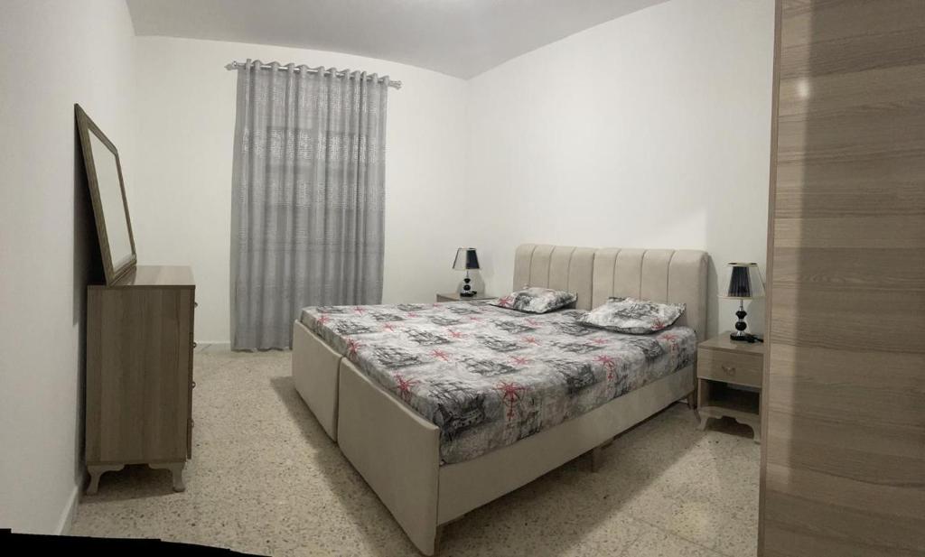 una camera da letto con un letto, un comò e una finestra di Babylon Gardens a Sousse