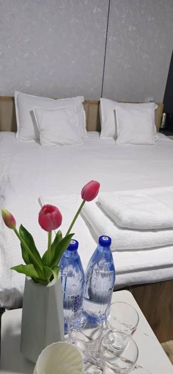 a table with two blue vases and a bed at 10 USD New Hotel in Tashkent