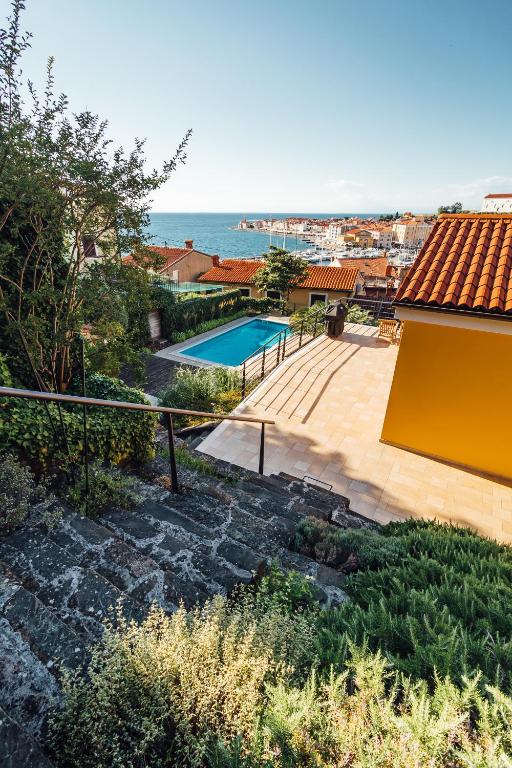 a house with a swimming pool next to the ocean at Piran Panorama Pool Villa in Piran