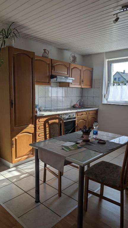 a kitchen with wooden cabinets and a table in it at Waldesruh in Pirmasens