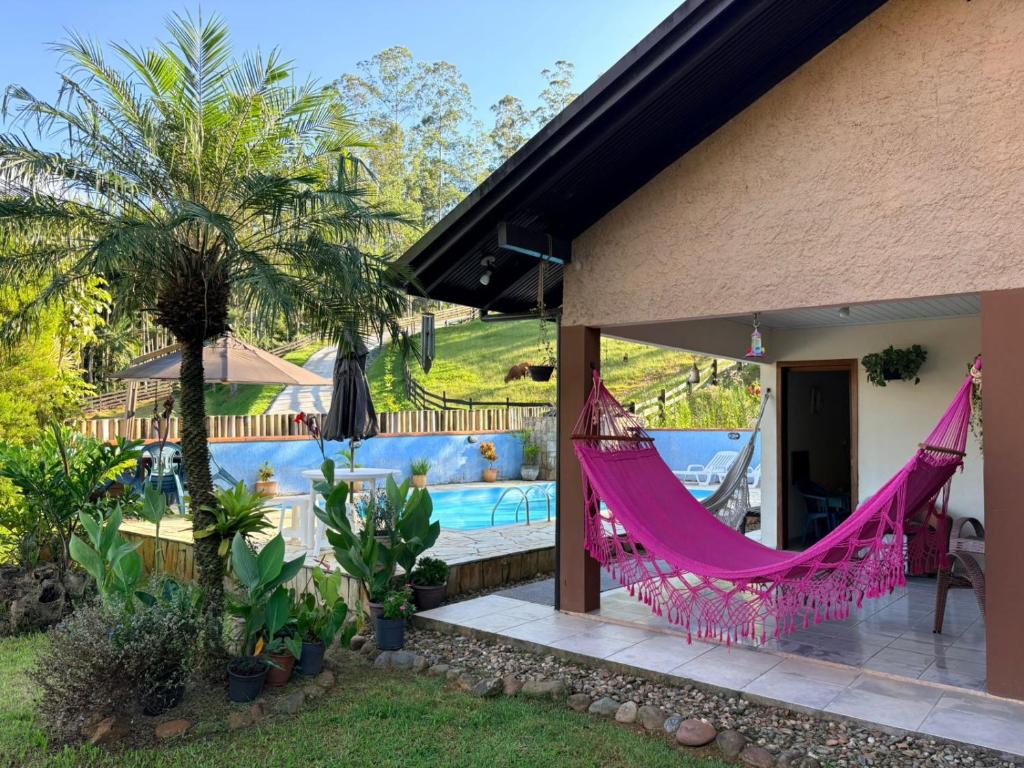 a house with a hammock and a swimming pool at Paraíso Pomerode in Pomerode