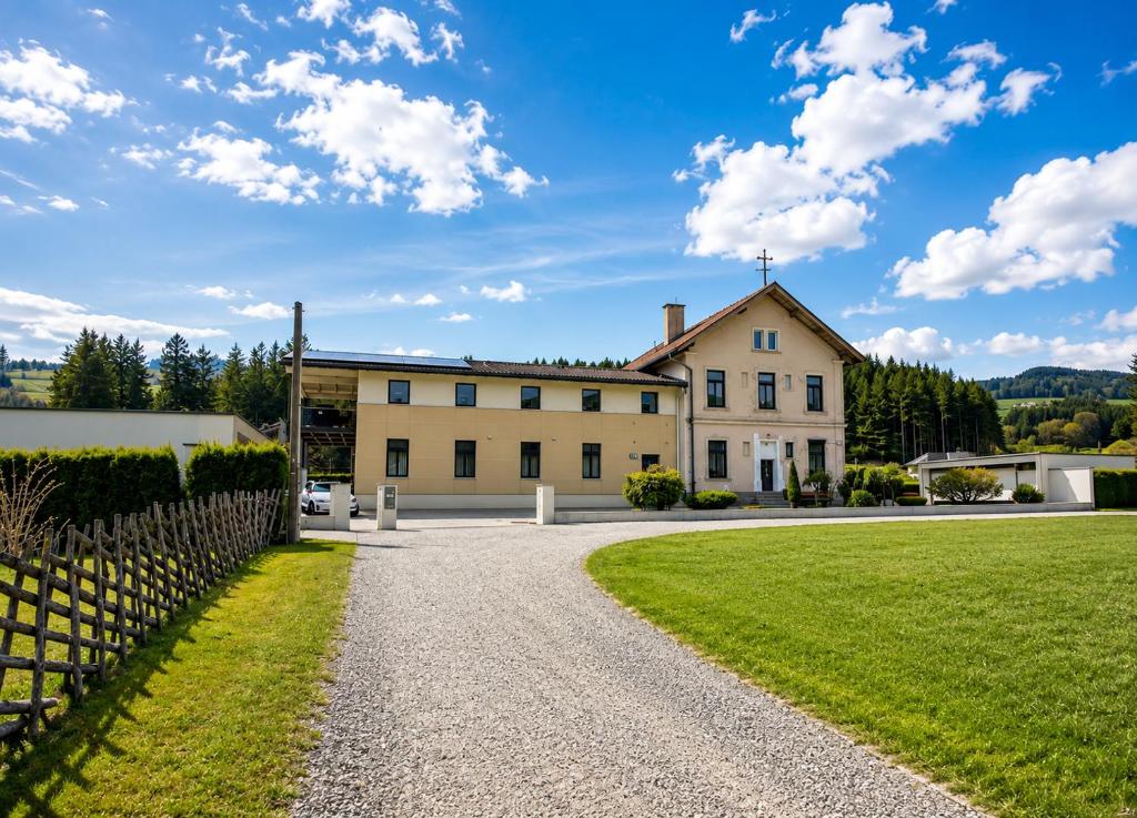 an exterior view of a large house with a gravel driveway at Lavanttalbahn Suite in Bad Sankt Leonhard im Lavanttal