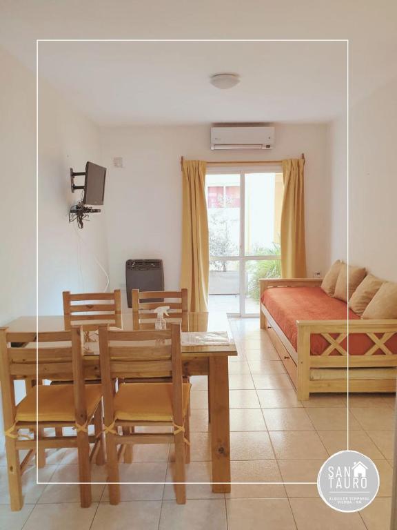 a living room with a dining table and a bed at SAN TAURO VIEDMA in Viedma