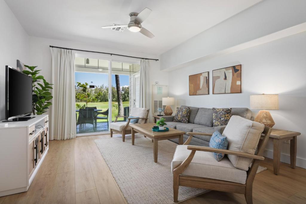 a living room with a couch and a tv at Fairway Villas Waikoloa by OUTRIGGER in Waikoloa