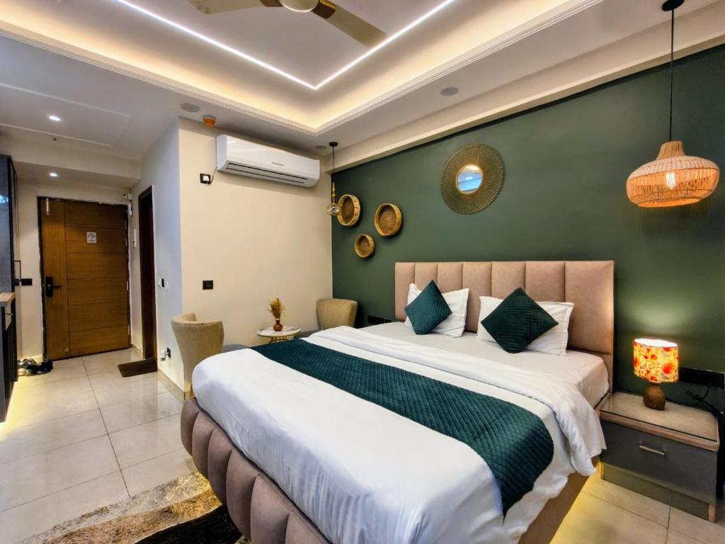 a bedroom with a large bed and a green wall at Cozyco Stays in Nalmatha