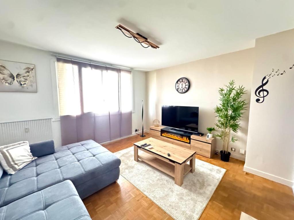a living room with a blue couch and a coffee table at Le petit sauna de Sarah in Voiron