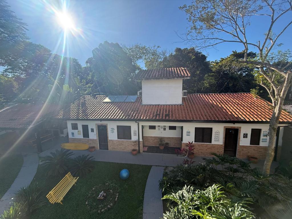a white house with a red roof at Pousada Bahan Suites privativas - ideal para Casais in Ubatuba