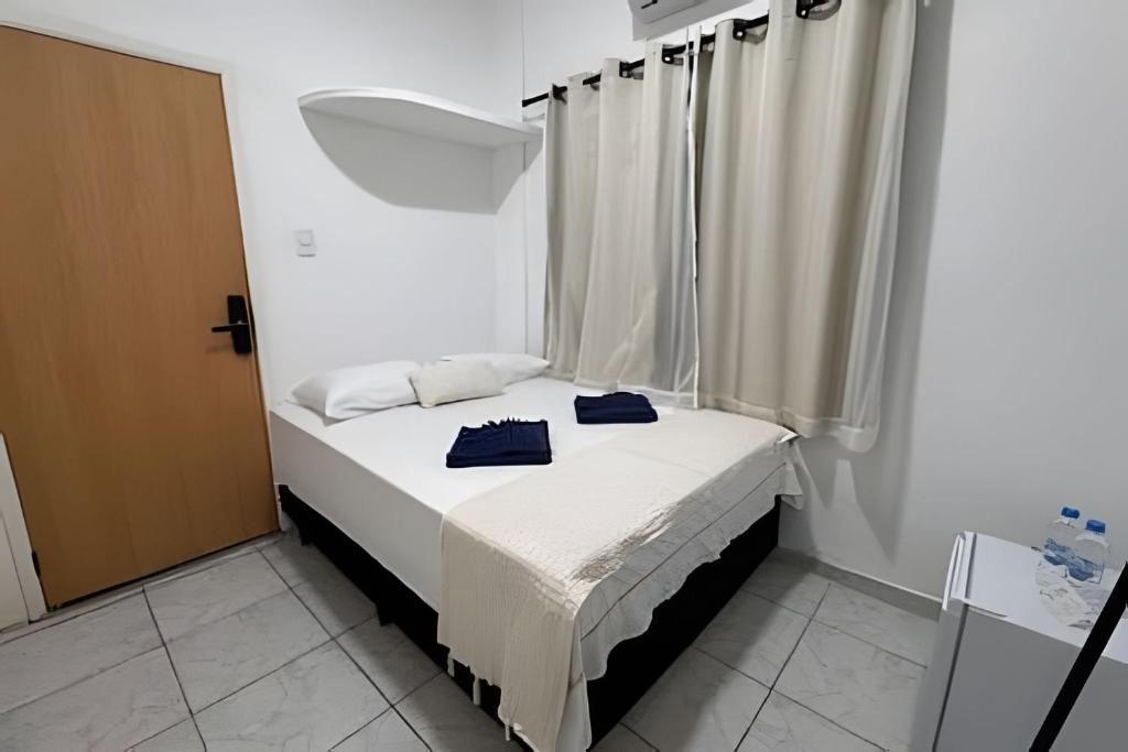 a small bed in a room with a window at Abaíra Serra Azul Suítes 02 - Centro in Petrolina