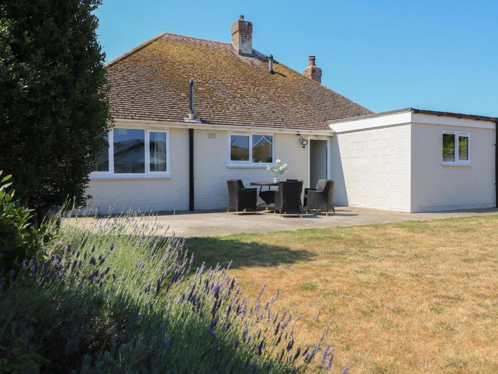 a house with a table and chairs in a yard at Bayview Cottage in Bournemouth