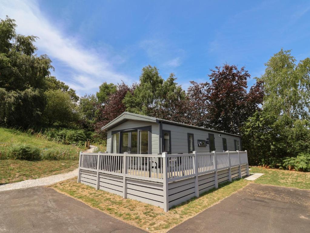 a small house with a white fence at The Pines 3 Bedrooms in Northwich
