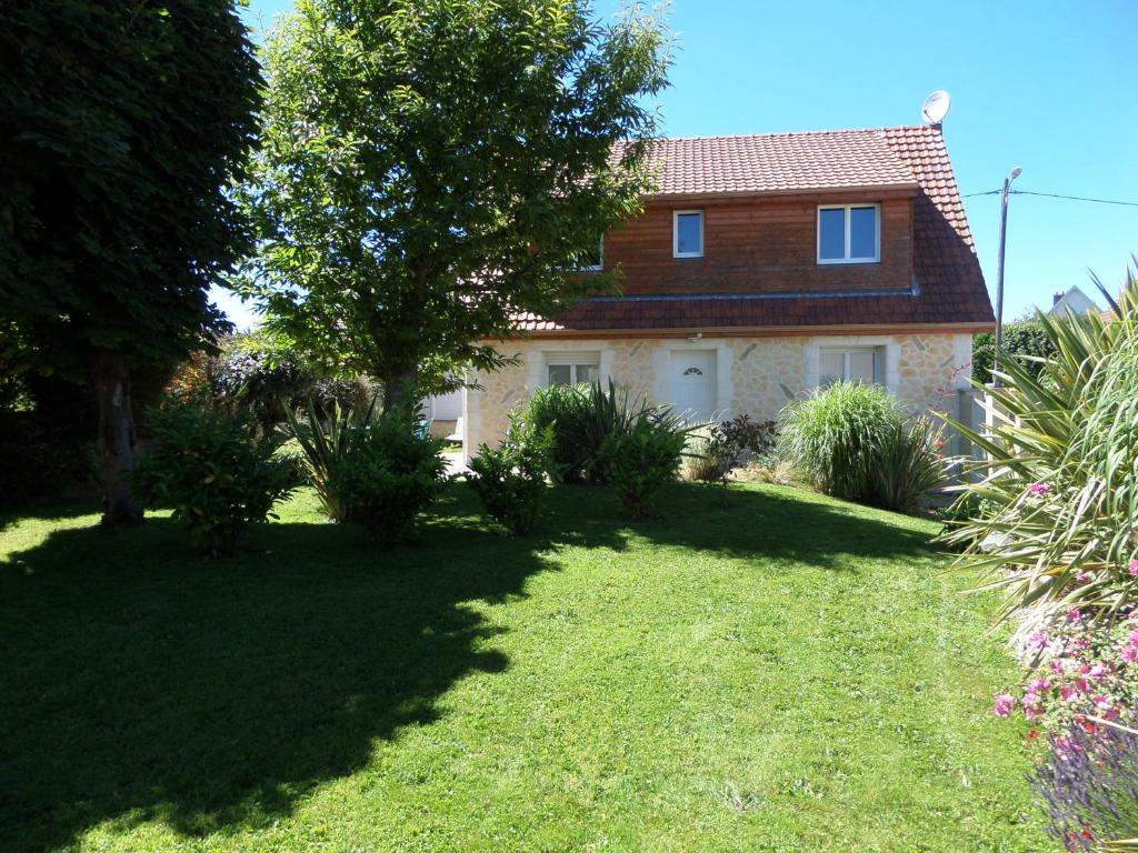 une maison avec un arbre dans une cour dans l'établissement Gite des galets, à Saint-Léonard