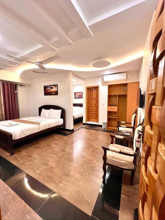 a hotel room with a bed and a desk at AAKAS Hotel & Restaurant in Muzaffarabad