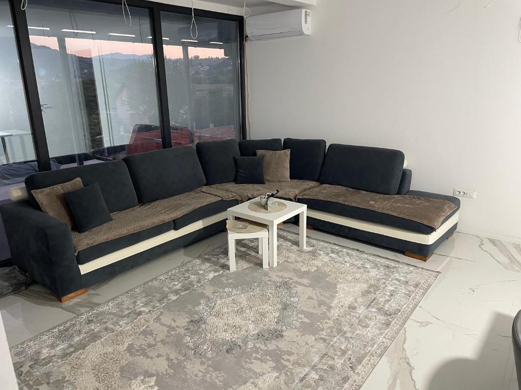 a living room with a blue couch and a table at Apartmen Emina 1 in Doglodi
