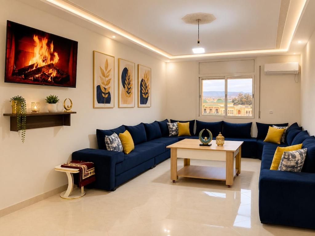 a living room with a blue couch and a table at Luxury Apartment Elevator FIBER WIFI in Oujda