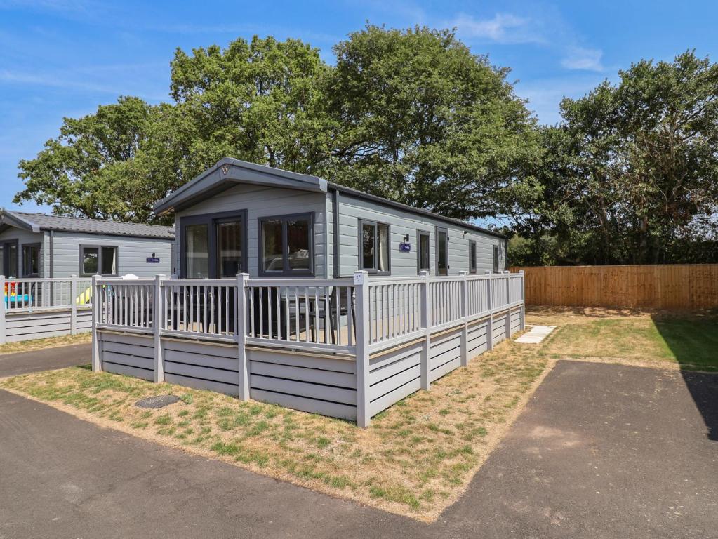 a mobile home with a white fence at The Oaks 3 Bedrooms in Northwich