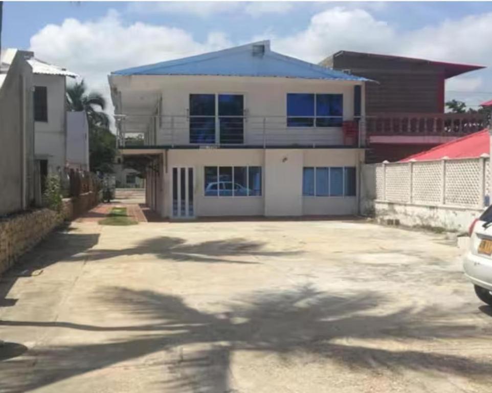 a large white house with a parking lot at Cabañas Calipso # 7 in Coveñas