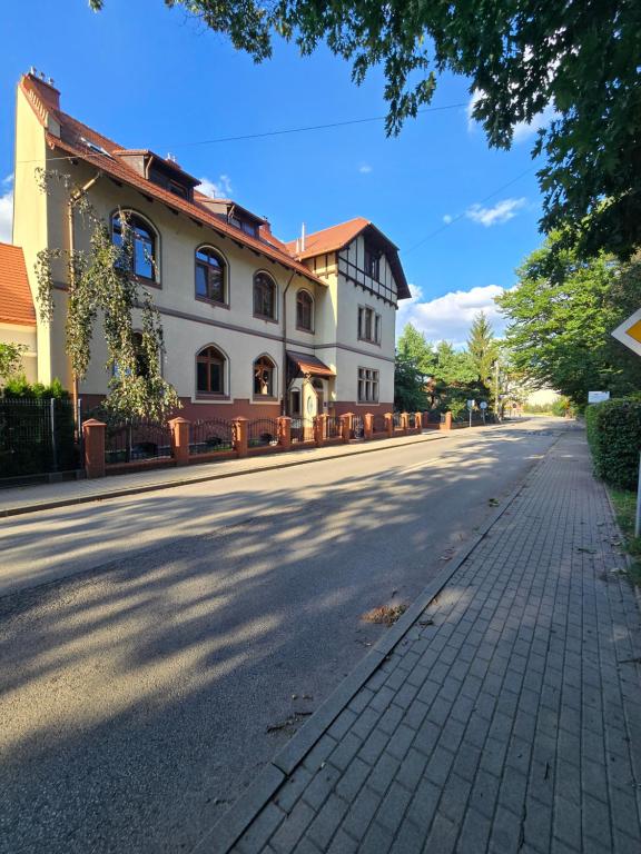 an empty street in front of a large building at Willa Carcassonne in Paczków