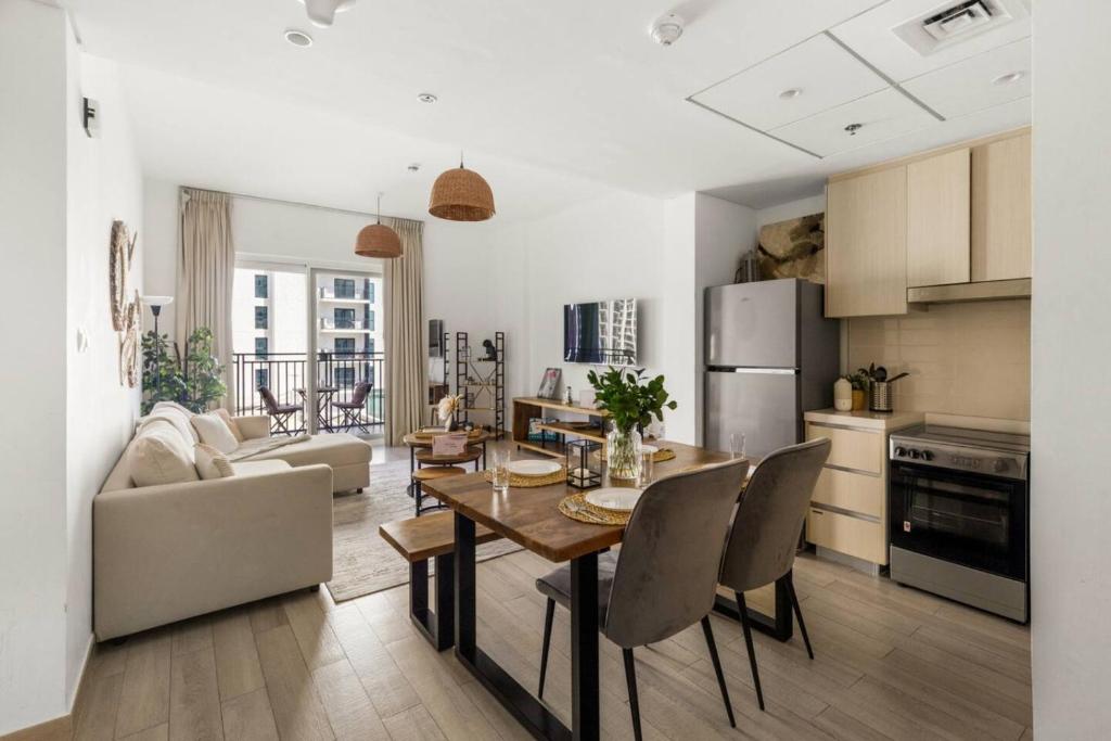 a kitchen and living room with a table and chairs at Waterfront Yas 1BR near F1 & Ticket Savings in Abu Dhabi