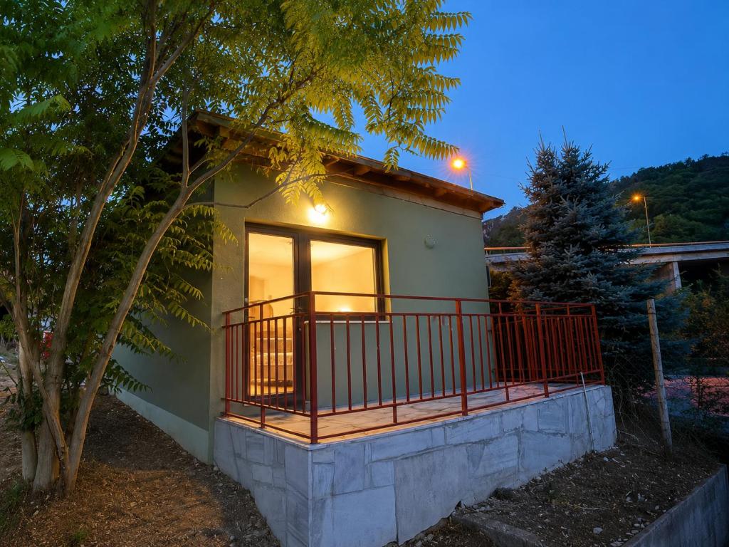 a small house with a balcony and a tree at Hidden Hills Cottage Sarajevo in Sarajevo