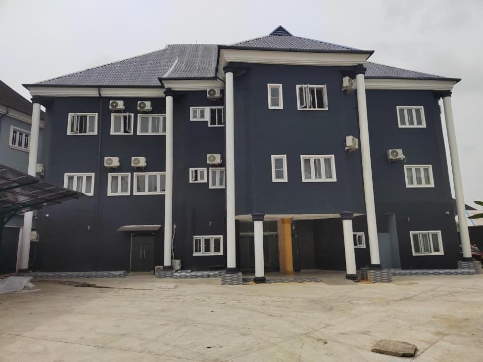 a large black building with white windows on it at IBK's Hotels and Suites in Rumuola